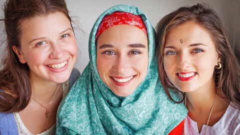 Drei Frauen lächeln in die Kamera