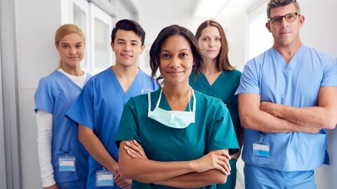 multikulturelles, medizinisches Teams, das im Krankenhauskorridor steht