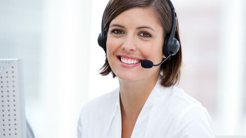 Telefonistin lächelt in die Kamera