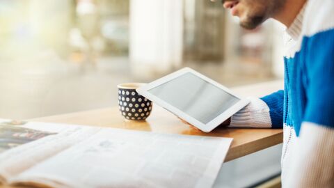 Zeitungslesender junger Mann