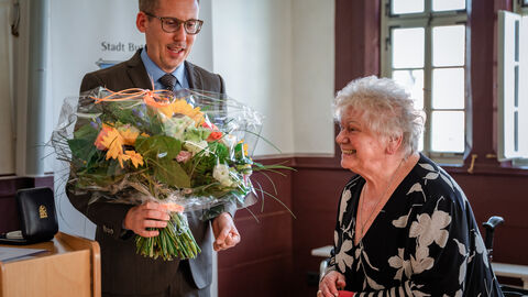 Minister Klose übergibt an Frau Jung einen Blumenstrauß im Rahmen der Verleihung Pflegemedaille