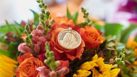Eine Bernhardt-Christoph-Faust Medaille fotografiert auf einem Blumenstrauß