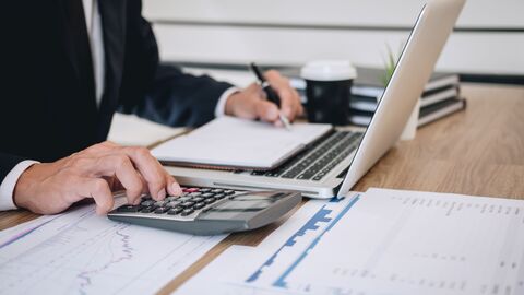 Geschäftsmann rechnet und prüft Summen