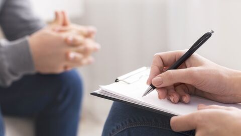 Therapeut macht sich während eines Gesprächs Notizen