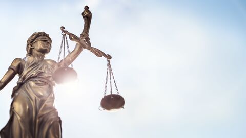 Statue von Justizia vor blauem Himmel