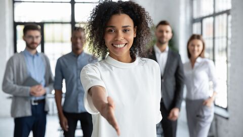 Eine Frau streckt lächelnd ihre die Hand aus 