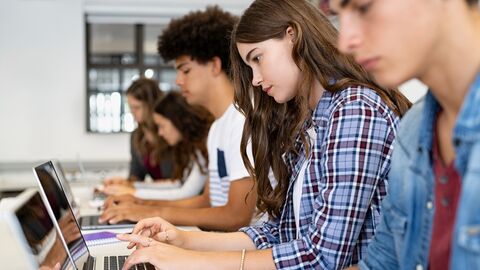 Gruppe von Gymnasiasten mit Laptop im Klassenzimmer