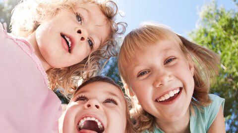 Drei kleine Mädchen lachen in die Kamera Drei kleine Mädchen lachen in die Kamera
