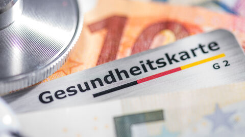 Gesundheitskarte und Geldscheine mit Stethoskop im Foto Gesundheitskarte und Geldscheine mit Stethoskop im Foto