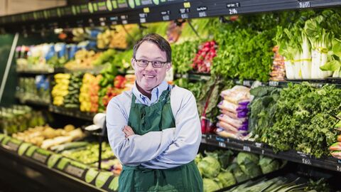 Ein junger Mann mit Down Syndrom arbeitet in einem Supermarkt