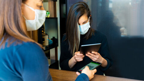 Eine junge Frau Checkt mit ihrem Handy im Restaurant ein