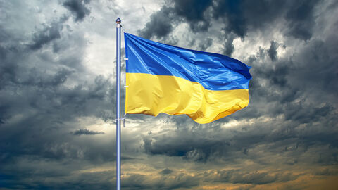 Ukrainische Flagge weht vor dunklen Wolken Ukrainische Flagge weht vor dunklen Wolken
