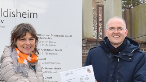 Staatssekretärin Anne Janz übergibt Jens Wehmeyer, kaufmännischer Vorstand des Bathildisheim e.V. den Förderbscheid