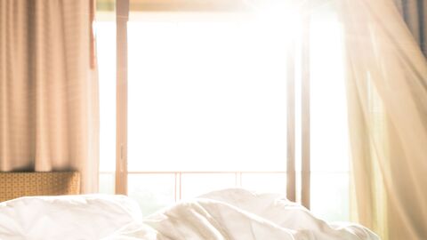 Es wird ein heißer Sonnentag, offenes Fenster mit wehenden Vorhängen