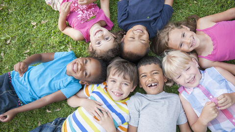 Kinder liegen im Gras