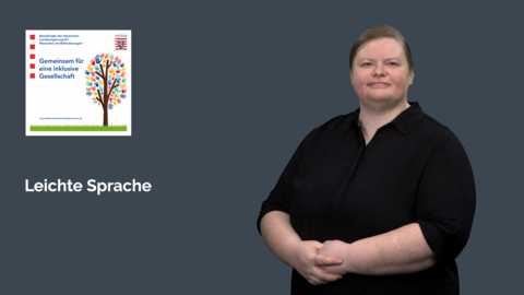 DGS-Dolmetscherin vor dem Logo der LBB