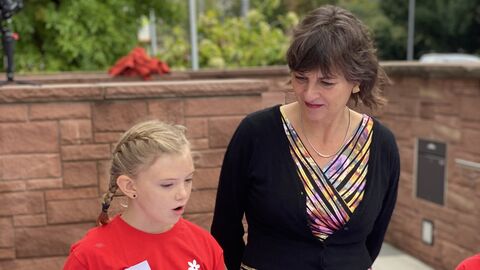 Grundschülerin Mayla erzählt der hessischen Staatssekretärin für Soziales und Integration Anne Janz wie sie die Kinderrechtefahne zusammen mit den anderen Schülerinnen und Schülern gestaltet hat