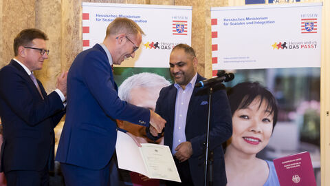 Alaa Abdullah aus Linden erhält seine Einbürgerungsurkunde