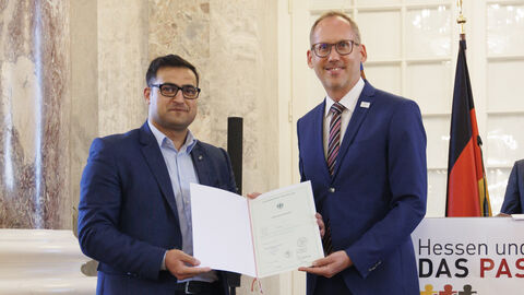 Einbürgerungsfeier 2023 Minister Klose mit Rafik Alkhouli bei der Einbürgerungsfeier. Alkhouli hält die Einbürgerungsurkunde in den Händen.