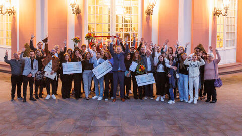 Sozial- und Integrationsminister Kai Klose zusammen mit den Gewinner*innen des Interationspreises 2023 vor dem Schloss Biebrich in Wiesbaden