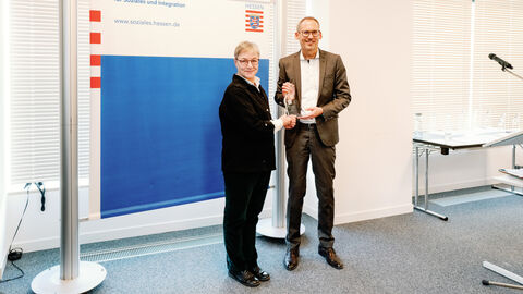 Presträgerin Corinna Fuchs neben Sozialminister Klose. Beide lächeln in die Kamera.