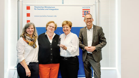 Drei Frauen von "Kochen für Rüsselsheim" gemeinsam neben Sozialminister Klose. Alle lächeln in die Kamera.