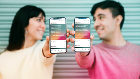 Eine junge Frau und ein junger Mann halten dem Betrachtenden ihre Smartphones entgegen. Diese sind scharf im Fokus und zeigen die Motive „GEWALT GEGEN FRAUEN“ und „FEMIZID“.