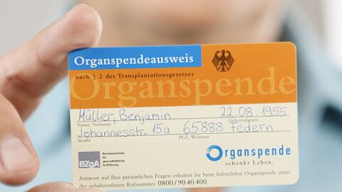 Eine Person hält einen Organspendeausweis in die Kamera.