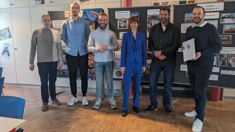 Die Ministerin für Arbeit, Integration, Jugend und Soziales, Heike Hofmann steht gemeinsam mit 5 Männern der Stadt Pfungstad vor Flipcharts 