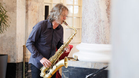 Ein Mann spielt auf einem Saxophon.