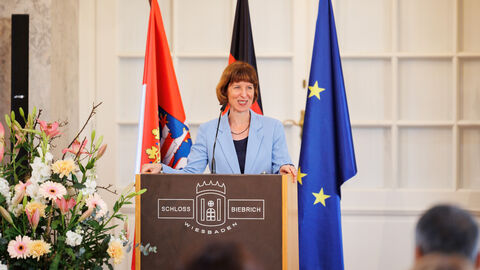 Integrationsministerin Hofmann steht an einem Rednerpult und hält eine Rede.