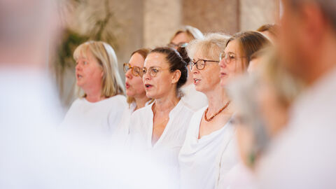 Ehrenamtlich aktive Integrationslotsinnen und -lotsen Mehrere Frauen in einem Chor. Sie singen.