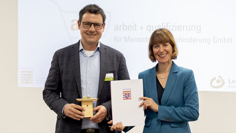 Preisverleihung Landespreis 2024 Sozialministerin Hofmann überreicht eine Urkunde an einen Herrn.