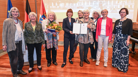 Die Preiträgerinnen bei der Übergabe des Preises mit Ministerin Hofmann in einem schönen Saal.