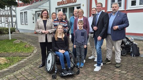 Eine Gruppe von 11 Personen vor einem Fachwerkhaus mit der Aufschrift "Gemeinde Knüllwald".