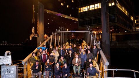 Die Teilnehmenden der 70. KBB stehen auf einem Schiffsanleger vor der Elbphilharmonie.